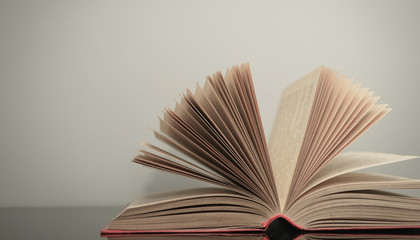 Poster - Beautiful open book on a gray and glass table background.