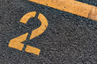 © RPA_studio - Asphalt parking lot with yellow lot line and yellow lot number 2