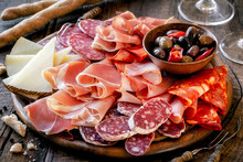 Cures Meat Platter With Cheese And Spicy Olives Served As Traditional Spanish Tapas On A Wooden Board. Selection Of Ham, Salami And Goat Cheese