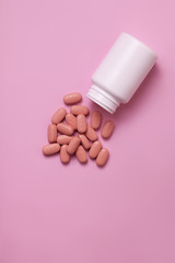 Wall Mural - HIV/AIDS therapy pills on pink background.