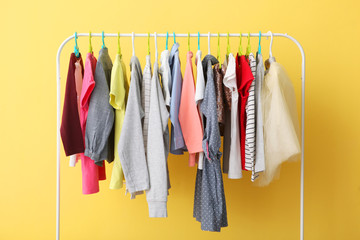 Wall Mural - Children clothes on a hanger on a colored background. Children's clothing, children's shopping.