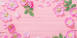 Fototapeta Tulipany - frame of pink roses on pink wooden background