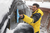 Fototapeta  - Man cleaning snow from car window outdoors on winter day