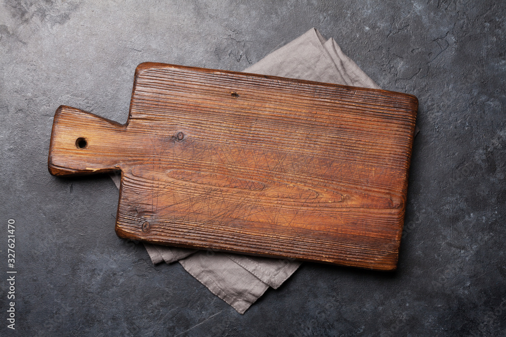 Cutting board over towel on stone kitchen table - obrazy, fototapety, plakaty 