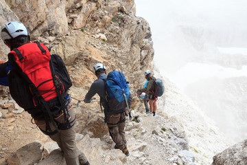 people climbing the via ferrata sentiero benini in brenta dolomites mountains, italy