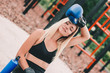 © Artem - Portrait of tired beautiful blonde sports girl posing in boxing gloves and smiling while sitting on sports ground. Happy attractive young fitness woman having rest after boxing training outdoors
