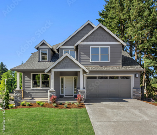 Cuadros en Lienzo Suburban home exterior on bright sunny day, with large yard and covered porch