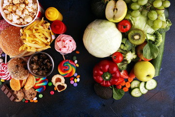 Wall Mural - healthy or unhealthy food. Concept photo of healthy and unhealthy food. Fruits and vegetables vs donuts,sweets and burgers