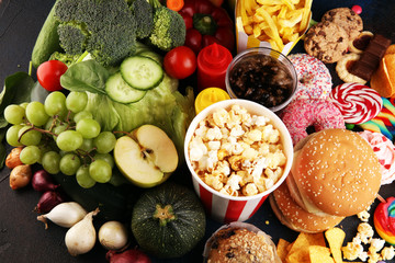 Wall Mural - healthy or unhealthy food. Concept photo of healthy and unhealthy food. Fruits and vegetables vs donuts,sweets and burgers