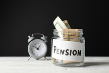 Glass Jar With Money And Alarm Clock Against Black Background, Close Up