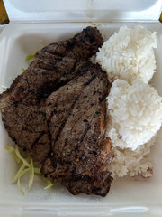 Sirlion Steak and two scoops of White Rice in a Styrofoam plate