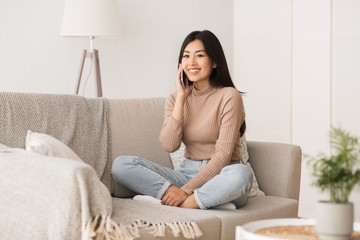 Free time. Happy asian girl chatting on phone and smiling