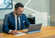 © isayurtsever - The boss, who checks and takes notes at the computer in his own workroom in the office, the handsome hardworking boss with the beard in the suit, the bank manager, the team leader