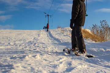 snowboarder and skier skiing on a ski slope, front and background blurred