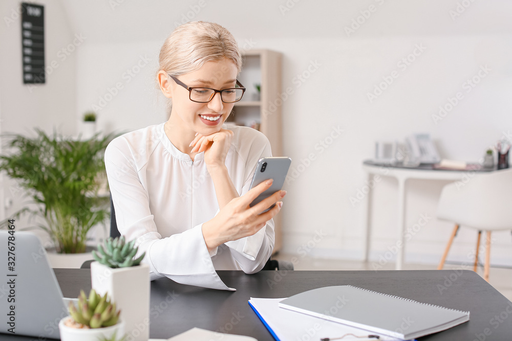 Young woman with mobile phone in office