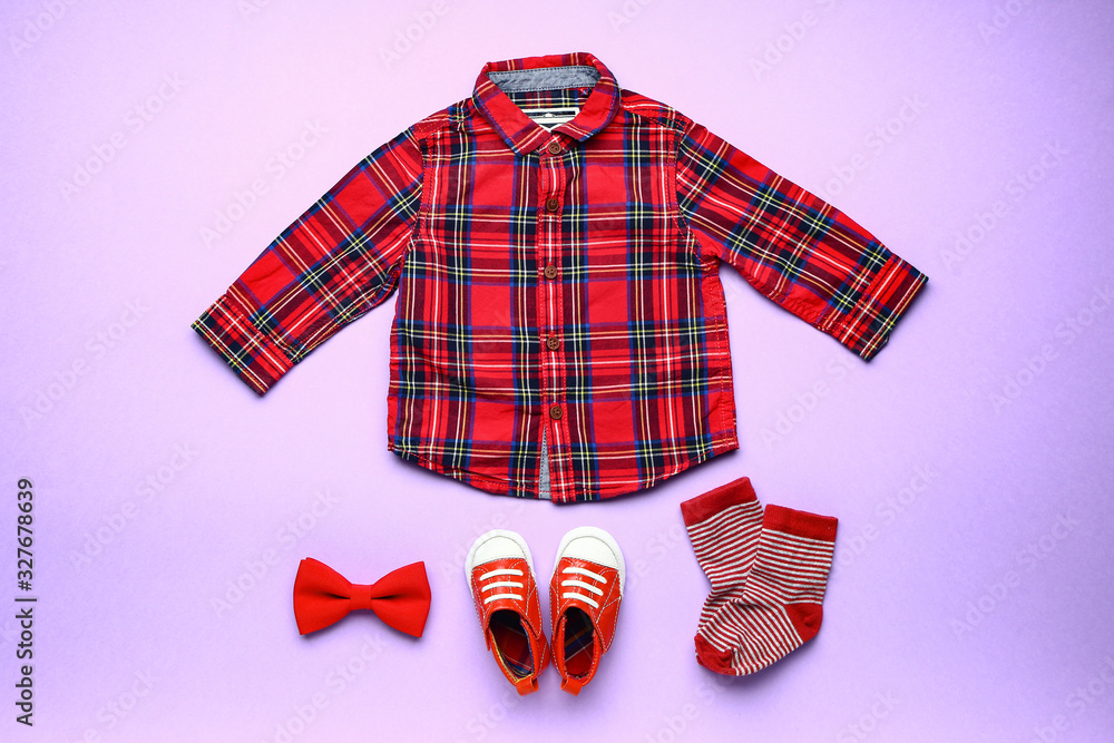 Baby clothes and accessories on color background