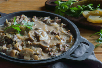 Wall Mural - beef Stroganoff in a frying pan on a wooden background