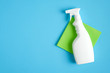 White cleaner spray bottle and green rag. Flat lay, top view. House cleaning service and housekeeping concept