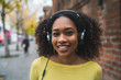 © Mego-studio - Portrait of young afro-american woman listening music with headphones.