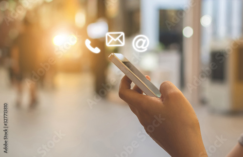 Fotografía Close up image hand using smartphone with icon telephone email mobile phone and address
