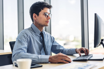 Handsome businessman relaxing using desktop computer while sitting on chair.creative business people working and management at modern office