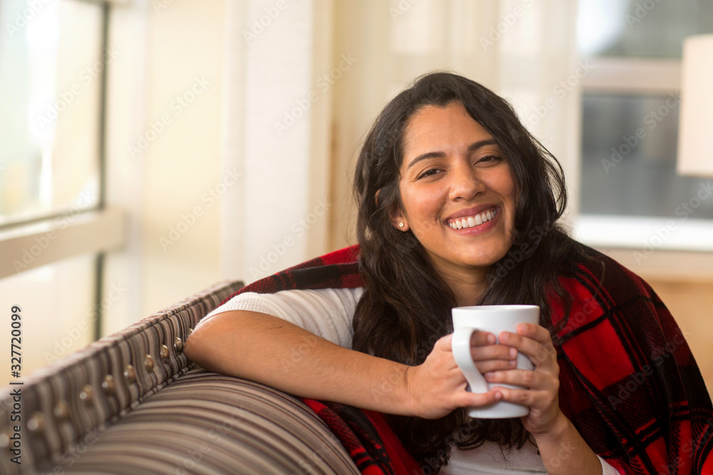 Portrait of a Hispanic woman wrapped in a cozy blanket. Stock Photo ...