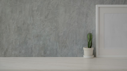 Close up view of simple copy space with mock-up frame and cactus pot on marble table