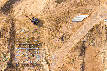 pile driver works to set precast concrete piles for foundation of new apartment building. aerial top view