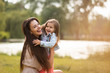 © Martinan - Young mother playing with daughter in park
