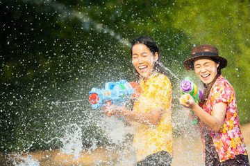 Wall Mural - Asian people are using water guns play songkran festival in the summer april