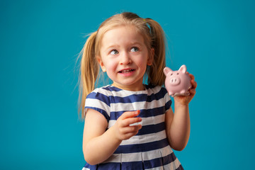 Funny little girl with piggy bank moneybox portrait