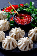 Canvas Print - Khinkali, Georgian dumplings on a black plate