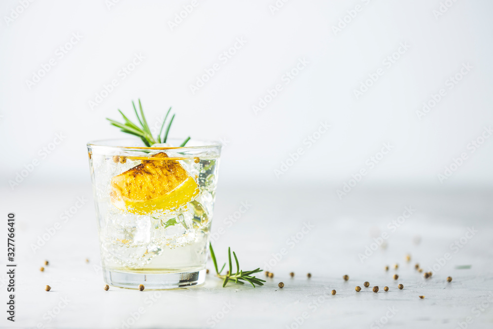 Charred Lemon, Rosemary and Coriander Gin and Tonic is a flavors are perfectly balanced refreshing cocktail. on light background, close up. Summer drinks and alcoholic cocktails - obrazy, fototapety, plakaty 
