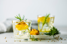 Glasses Of Gin And Tonic With Charred Lemon, Rosemary And Coriander Is A Flavors Are Perfectly Balanced Refreshing Cocktail. On Light Background, Close Up Surrounded Ingredients, Selective Focus