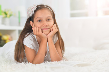 Poster - Close up portrait of little cute girl reading book at home