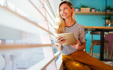 Wall Mural - Portrait of pretty student or businesswoman in smart casual using digital tablet