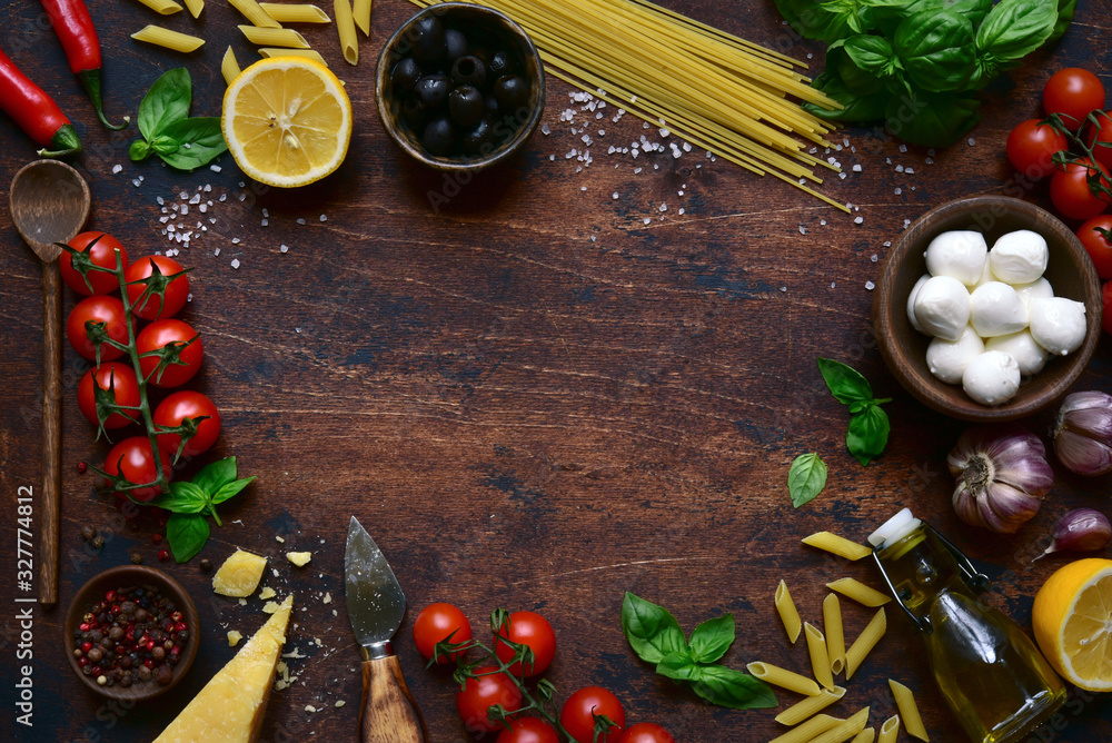 Traditional ingredients of italian cuisine : pasta, cheese,tomatoes,garlic,olive oil, basil and lemons. Top view with copy space. - obrazy, fototapety, plakaty 