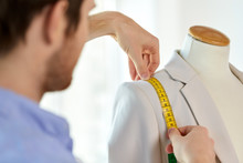 Tailoring, Sewing And Clothing Concept - Close Up Of Male Fashion Designer Measures Jacket With Tape Measure