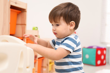 Wall Mural - Cute little child playing in modern playpen at home