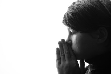 Black and white portrait of young sad boy crying with sad eyes. White background. Free space for text. Tear on cheek of unhappy teenager.