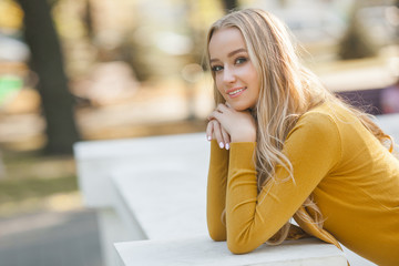 Young attractive woman outdoors. Pretty lady on urban background. Female close up portrait.