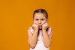 © producer - offended sad little child girl in dress on yellow background. Human emotions and facial expression