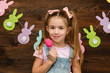© producer - happy little child girl holding painted Easter eggs. Easter day