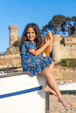 Fototapeta Londyn - Beautiful girl sitting on a fish boat