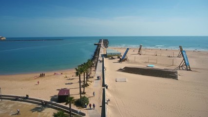 Canvas Print - Aerial. A pier and breakwaters at the entrance to the Arade River aerial view. Cities of Portimao. Praia de Rocha.