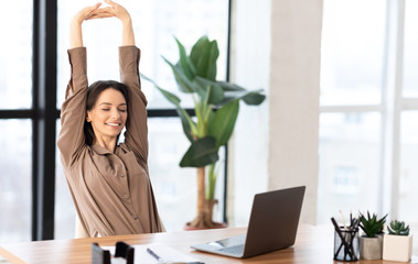 Wall Mural - Happy caucasian girl stretching body at workplace