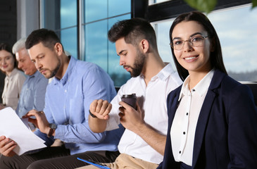 Wall Mural - Young woman with eyeglasses waiting for job interview in office hall