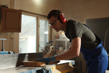 Sticker - Professional carpenter working with wood in shop