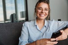 Image Of Happy Young Woman In Eyeglasses Smiling And Using Cellphone