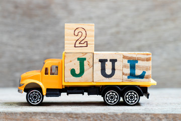 Wall Mural - Truck hold letter block in word 2jul on wood background (Concept for date 2 month July)